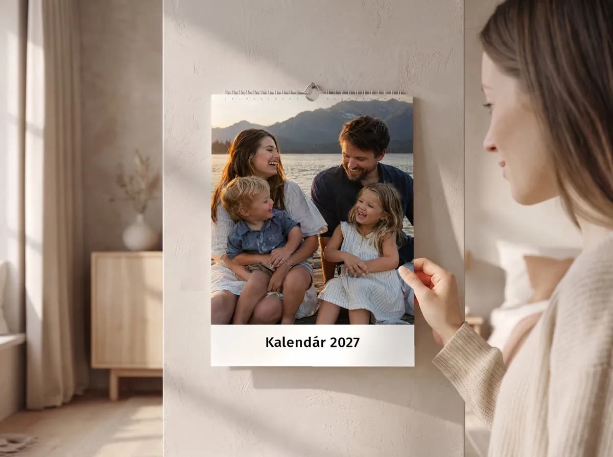 Fotokalendár zavesený v kuchyni vedľa police s hrnčekmi