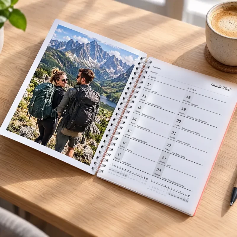 Dvojtýždenný fotodiár so špirálou otvorený na stole — vľavo fotografia turistov v horách, vpravo dva týždne januára 2027 vedľa seba na jednej strane